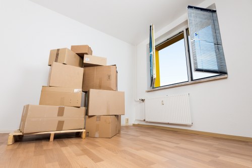 Two movers carrying furniture during a local house move in Yiewsley